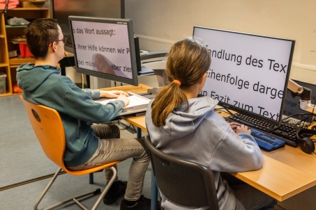 Schüler*innen nutzen zum Lesen Bildschirmlesegerät und Braillezeile