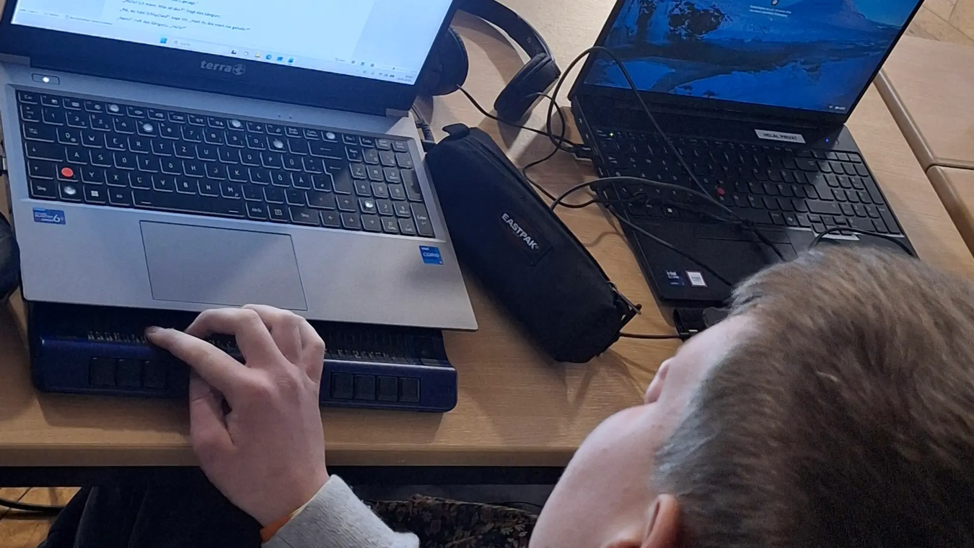 Auf dem Foto sind insgesamt sieben Schüler*innen, zu einem Gruppenfoto aufgestellt, zu sehen. Sie halten Urkunden sowie einen Pokal. Vier Gesichter sind mit Smileys abgedeckt. Im Hintergrund ist die Leinwand mit dem Plakat des Lesewettbewerbs zu sehen.