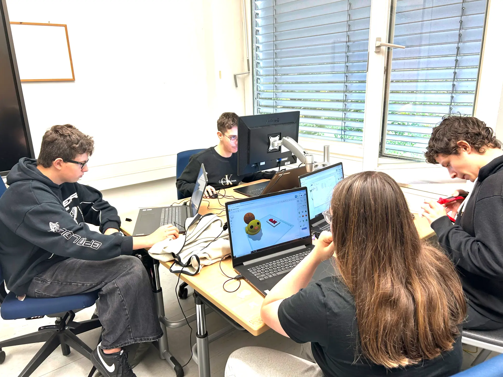 Die Schüler*innen sitzen am Computer und erstellen die Druckaufträge für den 3D-Drucker